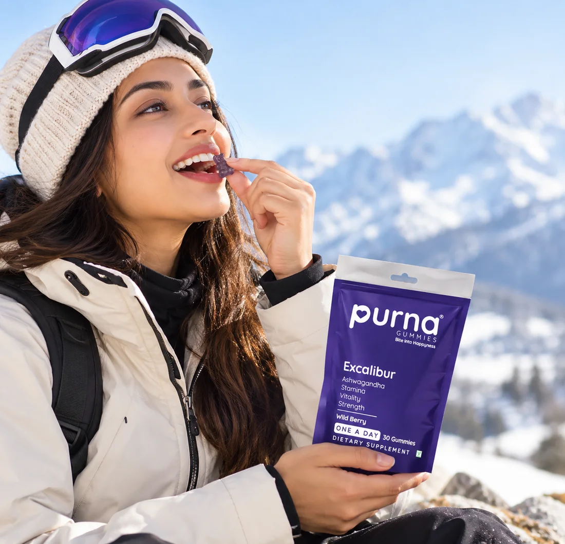 Woman in the snowy mountains enjoying a Purna Excalibur Ashwagandha gummy